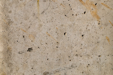 Surface of concrete slab with beige spots and black dots, stone texture.
