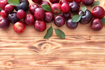 Ripe juicy plums on wooden table