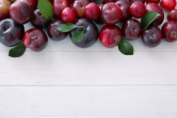 Ripe juicy plums on wooden table