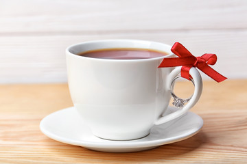 Engagement ring tied to cup of coffee on table, closeup