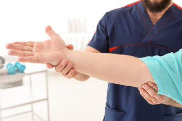 Young physiotherapist working with patient in clinic