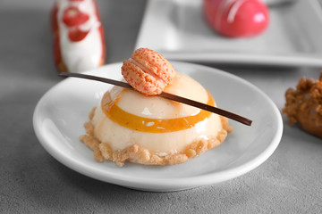 Plate with tasty cake on table