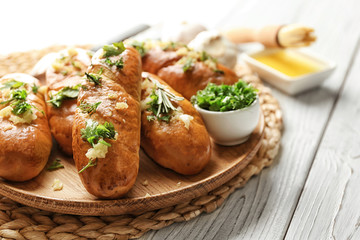 Plate with delicious homemade garlic bread on table