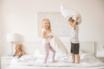 Obraz na płótnie Canvas Cute children having fun on bed together