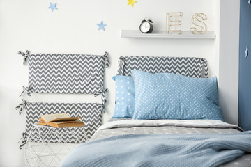 Comfortable bed with soft pillows in modern child room