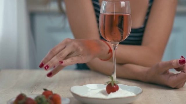 Young woman on kitchen with glass of wine, slow motion, shallow depth of field