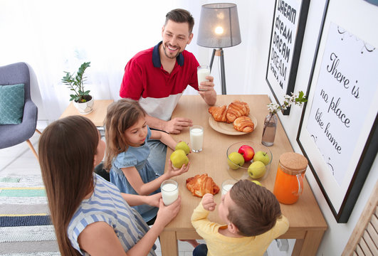 Happy family having breakfast with milk at table