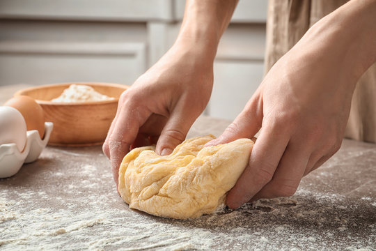 Woman kneading dough for pasta at table