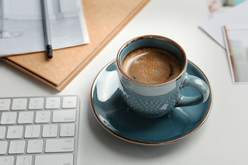 Cup of delicious hot coffee on table