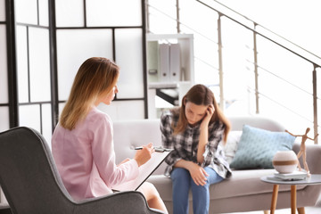 Child psychologist working with teenage girl in office