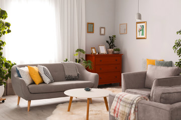Elegant living room interior with comfortable sofa and armchairs