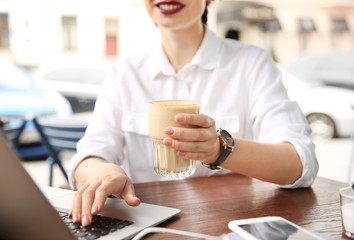 Young woman working with laptop at desk, closeup
