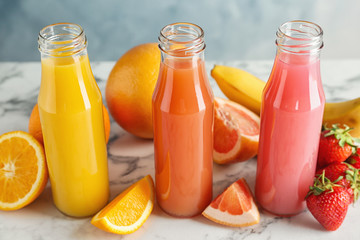 Bottles with tasty juices and ingredients on table