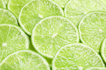 Fresh sliced ripe limes as background, closeup