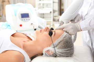 Young woman undergoing laser removal of permanent makeup in salon. Eyebrow correction