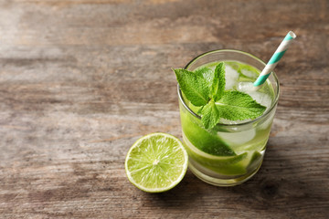Refreshing beverage with mint and lime in glasses on table, closeup
