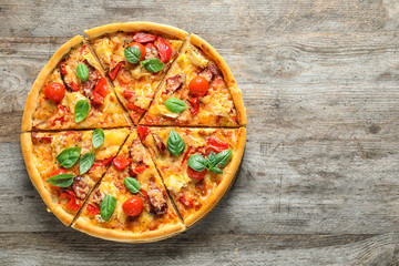 Delicious pizza with tomatoes and sausages on wooden table, top view