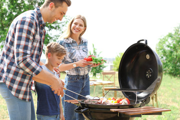 Happy family having barbecue with modern grill outdoors