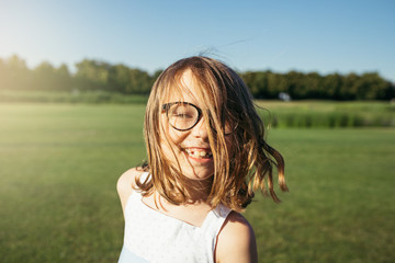 Girl looking at camera and smiling and fun. Summer leisure. Girl in glasses with black rim.