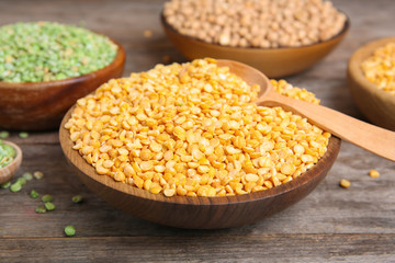 Bowl with dried peas on wooden table