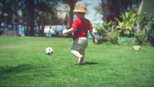 Cute little boy playing with soccer ball. Stock footage.