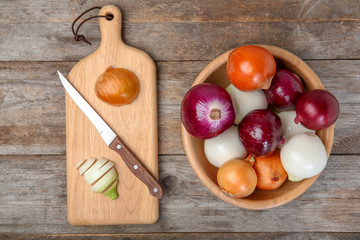Flat lay composition with fresh onions on wooden background