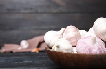 Plate with fresh garlic bulbs on table