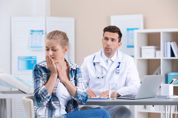 Obraz premium Coughing young woman visiting doctor at clinic
