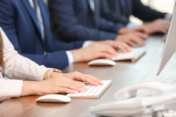 Technical support operators using computers at workplace, closeup