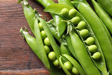 Fresh green peas on wooden background, closeup