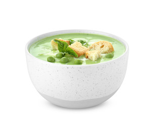 Green pea soup with croutons in bowl on white background