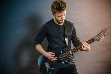 Obraz premium Young man playing electric guitar