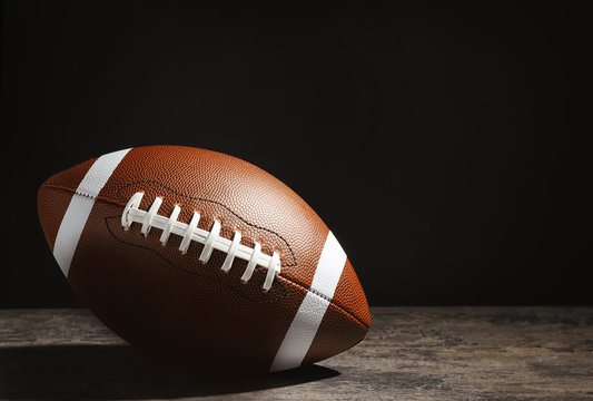 New American football ball on table against dark background