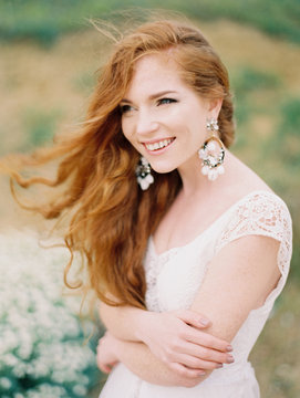 Smiling girl in dress and earrings posing