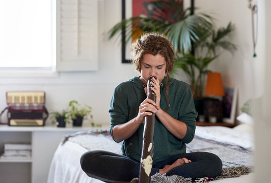 Portrait of young woman practising on didgeridoo
