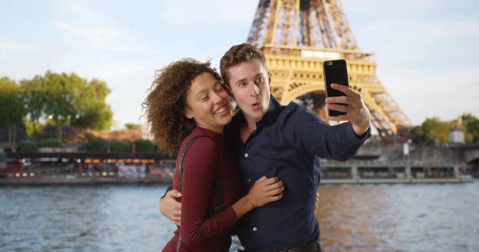 Happy and attractive couple take selfie by the Seine, Caucasian male and female pose for pictures together near the Eiffel Tower, 4k