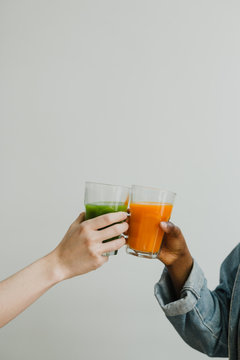 Friends drinking cold pressed juice together - cheers!
