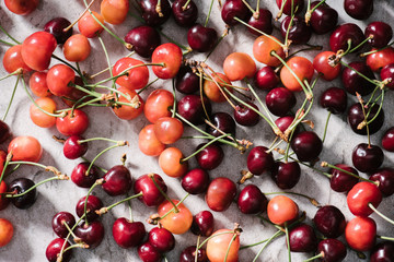 top view of fresh ripe organic cherries on marble surface