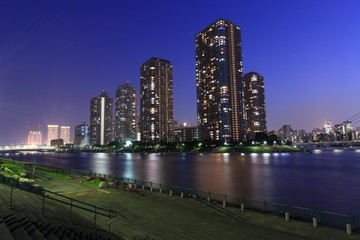 Fototapeta na wymiar 夜の隅田川と明かりの灯った高層マンション群