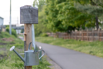 Sign and watering can at community farm