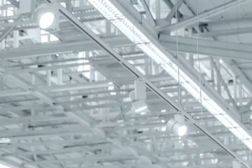 Deurstickers Industrieel gebouw rij heldere halogeenspots op tentoonstellingsplafond. industrieel gebouw interieur