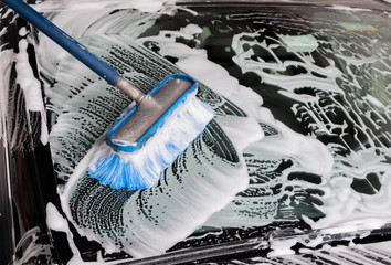 Car washing. Modern car covered by foam