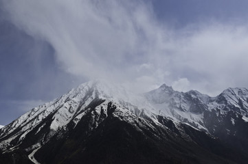 Obraz premium Himalaya - Snowy, Dark, Dramatic Mountain Peaks Dusted in Soft Clouds