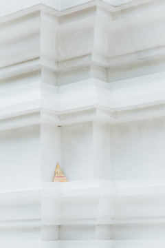 Little buddha statue on white pagoda
