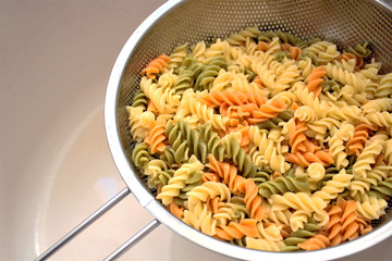 Fusilli (Fuso) - classic Italian pasta in the form of a spiral of durum wheat. Ingredient for cooking a traditional Italian dish. Cooking process. Soft focus, close-up. A place to copy.