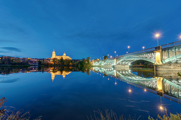 Fototapeta na wymiar The Cathedral of Salamanca and the river Tormes with the Puente de Enrique Estevan at night