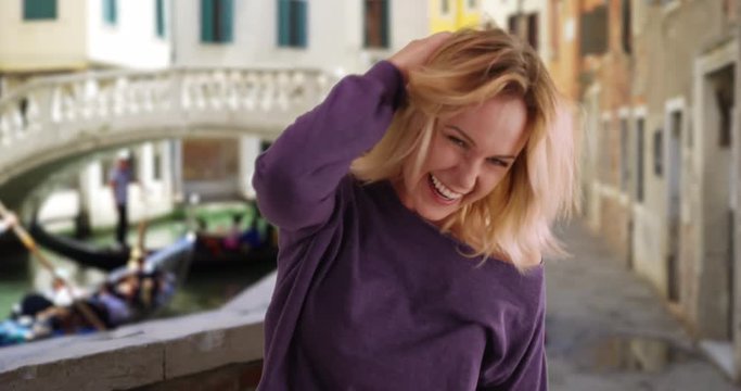 Energetic Caucasian Woman In Street In Venice, Italy Being Playful Outside, Attractive Female In Baggy Sweater Laughing With Delight At Camera In Venice, 4k