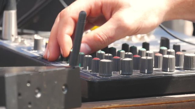 Man working on professional digital audio channel mixer. Electronics for amplifier and balance of sound in show. Soundboard knobs. sound engineer presses the keys, moves the buttons.