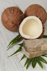 coconut soap.soap with coconut extract. Handmade soap with coconut oil on a palm leaf and fresh coconut in a cut on a shabby wooden background.  Organic   Cosmetics