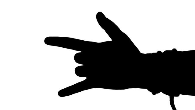 A female hand making the devil's horns gesture (rock on). Green background.
